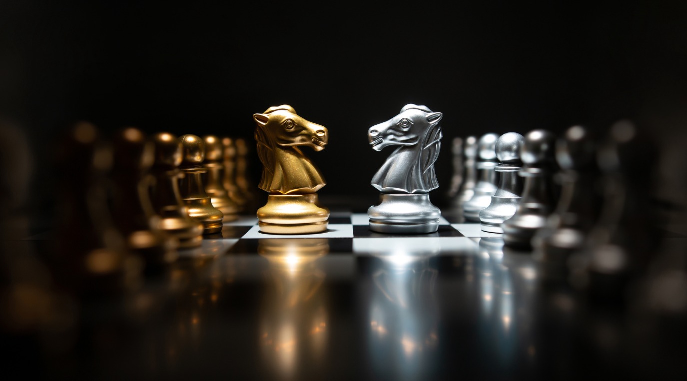 Golden and silver knights face off on a reflective chessboard.